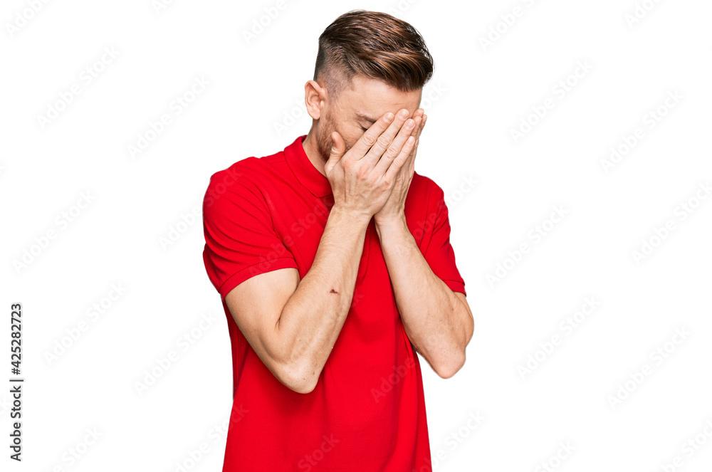 Young redhead man wearing casual clothes with sad expression covering face with hands while crying. depression concept. Young redhead man wearing casual clothes with sad expression covering face with hands while crying. depression concept.