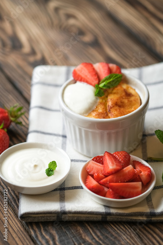 Cottage cheese casserole with strawberries and mint on a rustic background with copy space.