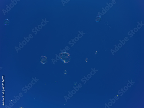 Soap bubbles flying in the clear blue sky