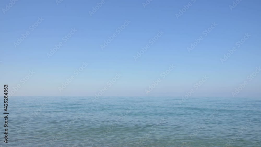 Morning view of the calm crystal clear water surface. Calm at sea. Lively background of tranquility