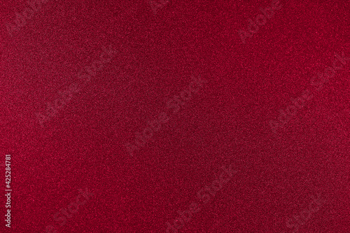 Rich red background color. One-color texture with a small noisy glitter. Copy space