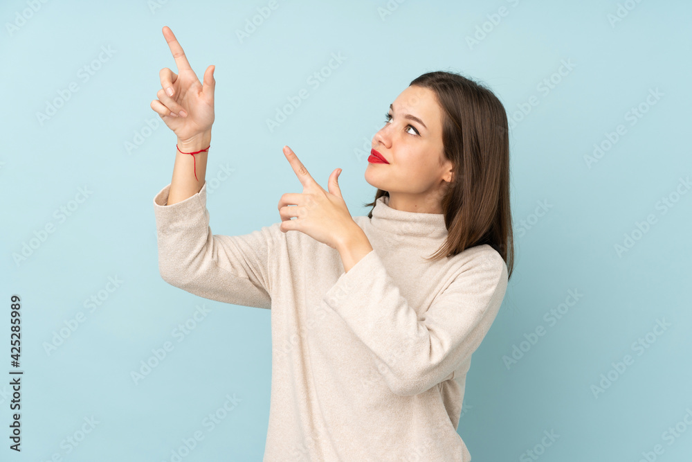 Teenager girl isolated on blue background pointing with the index finger a great idea Teenager girl isolated on blue background pointing with the index finger a great idea