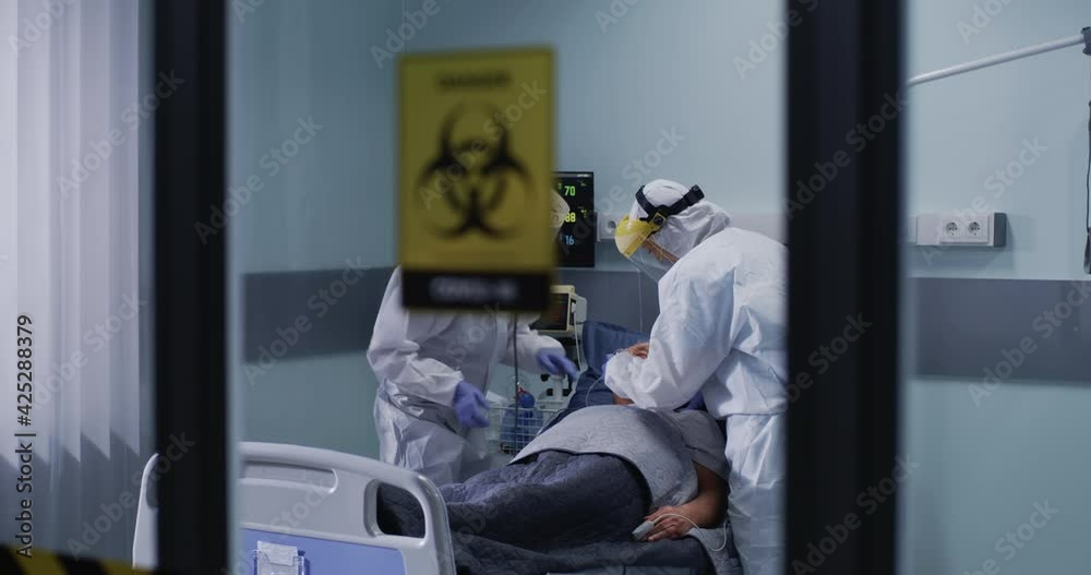 Doctors resuscitating senior patient in hospital ward