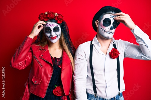 Couple wearing day of the dead costume over red worried and stressed about a problem with hand on forehead  nervous and anxious for crisis