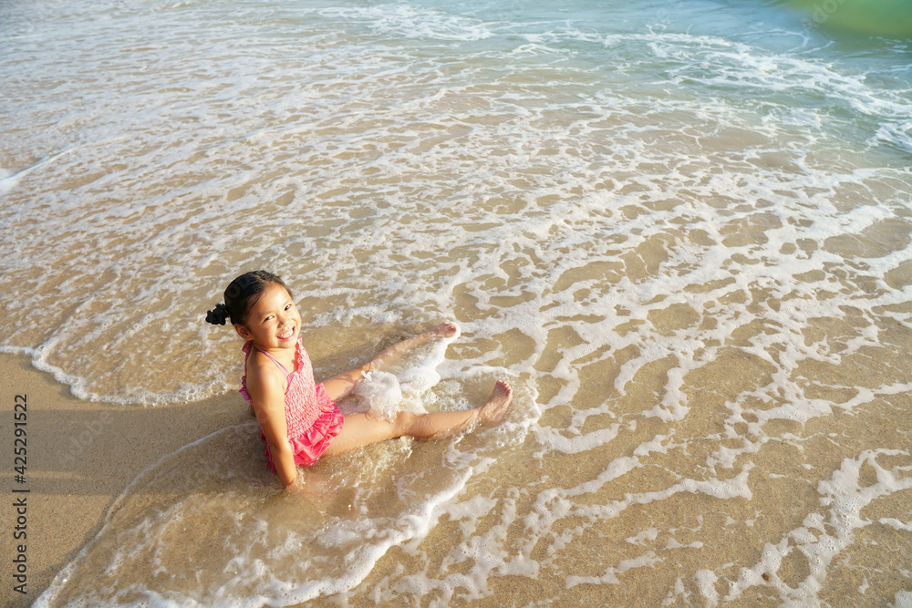 asian child or kid girl smiling enjoy sit on sand beach or sea to play alone with white wave bubble on morning sunrise or evening for vacation travel on family summer to happy holiday relax on bikini asian child or kid girl smiling enjoy sit on sand beach or sea to play alone with white wave bubble on morning sunrise or evening for vacation travel on family summer to happy holiday relax on bikini