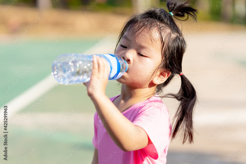 Asian child are drinking some water from plastic bottles. Cute girl thirsty. Hot summer or spring. Children sweats on the face. Kid is tired, aged 3-4 years old. Asian child are drinking some water from plastic bottles. Cute girl thirsty. Hot summer or spring. Children sweats on the face. Kid is tired, aged 3-4 years old.