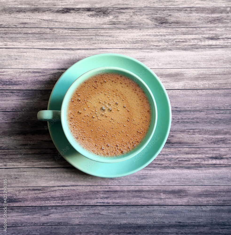 Blue coffee cup and saucer shot on wooden surface. Top view, from above, flat lay. Coffee break background. Blue coffee cup and saucer shot on wooden surface. Top view, from above, flat lay. Coffee break background.