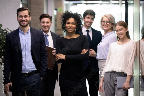 Portrait of happy multiethnic diverse employees colleagues pose together in office. Confident young successful African American businesswoman or team leader with staff show unity and leadership.