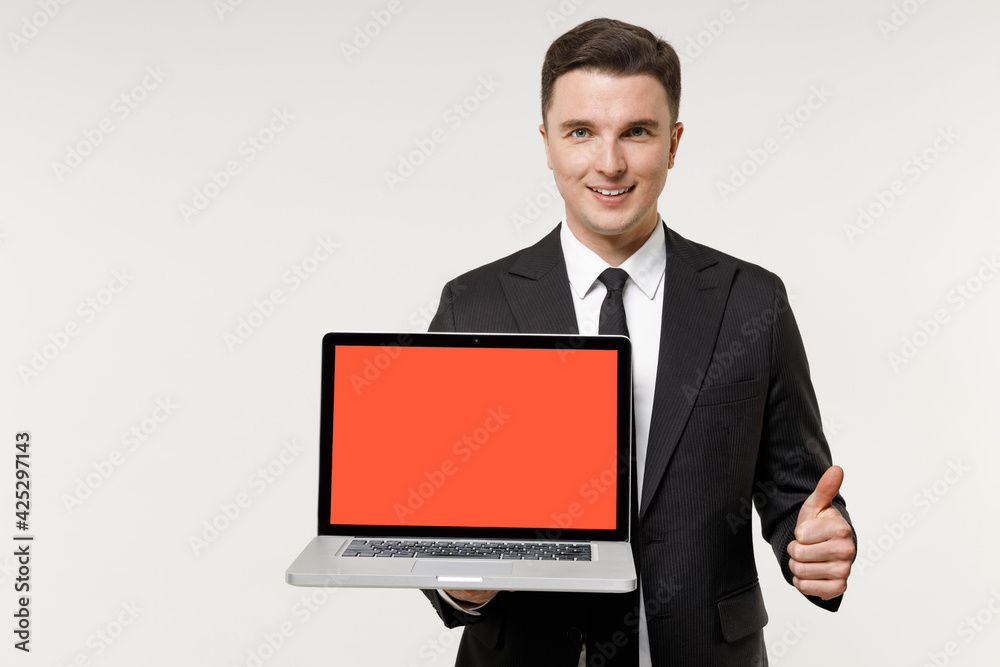 Young employee business corporate lawyer man in classic formal black grey suit shirt tie work in office hold laptop computer blank screen workspace show thumb up gesture isolated on white background. Young employee business corporate lawyer man in classic formal black grey suit shirt tie work in office hold laptop computer blank screen workspace show thumb up gesture isolated on white background.