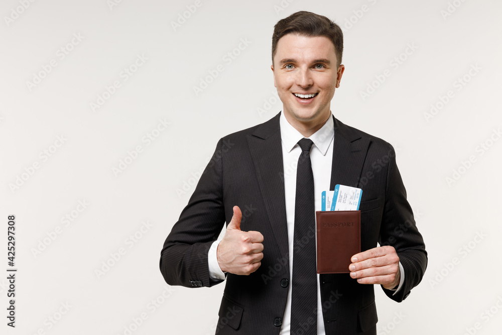 Traveler tourist business man in classic formal black suit hold passport ticket show thumb up isolated on white office background Passenger travel abroad weekends getaway Air flight journey concept. Traveler tourist business man in classic formal black suit hold passport ticket show thumb up isolated on white office background Passenger travel abroad weekends getaway Air flight journey concept.