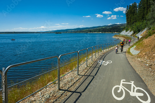 Fototapeta Naklejka Na Ścianę i Meble -  Family Cycling around Czorsztynskie lake near Niedzica village on sunny spring day, Pieniny Mountains, Poland