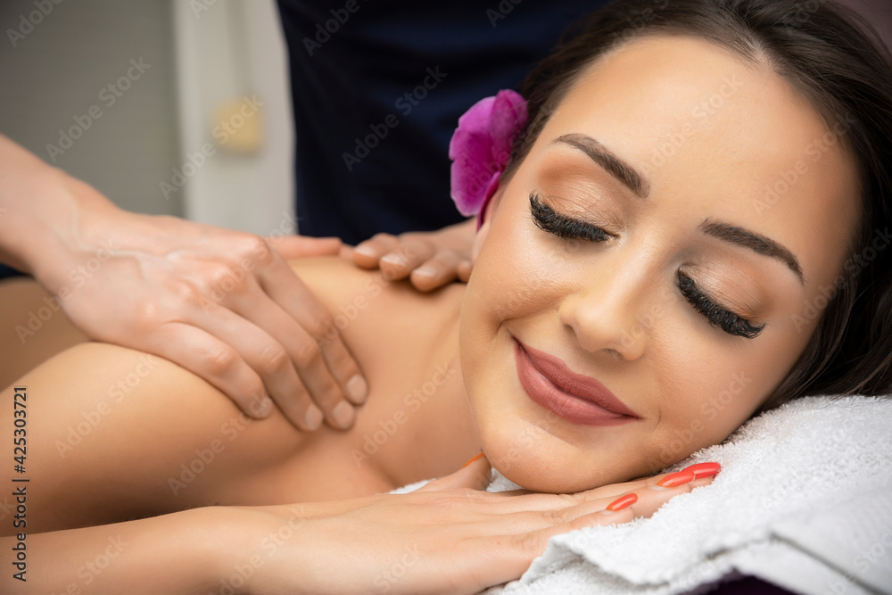 Woman doing relaxing back massage in spa center