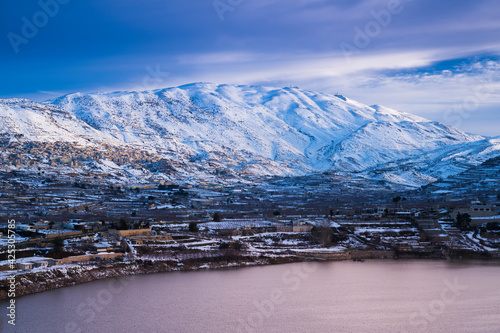 Beautiful winter morning landscape at Lake Ram or Birkat el-Ram, a crater lake (maar) in the northeastern Golan Heights, Israel, surrounded by snow-covered hills