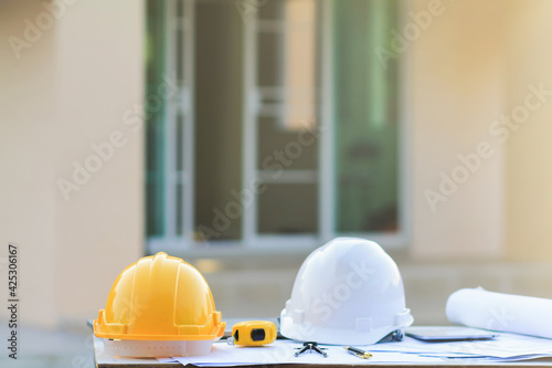 Canvastavla White helmets are placed on the side tables, documents and house plans to prepare teams of engineers and contractors to safely wear helmets into the construction site