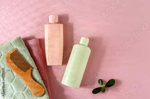 Cosmetic products for hair or skin care on pink backgroundr. Space for text. Flat lay composition photo