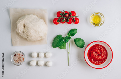 Composition with fresh basil, dough, mozzarella, olive oil. Ingredients for Margherita pizza isolated on white