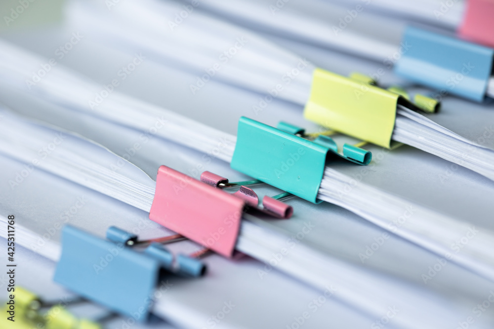 Piles of white papers work large piles of papers stacked together. On the desk in the office with colorful clip. Documents that are not finished in the office. Business concept. Piles of white papers work large piles of papers stacked together. On the desk in the office with colorful clip. Documents that are not finished in the office. Business concept.