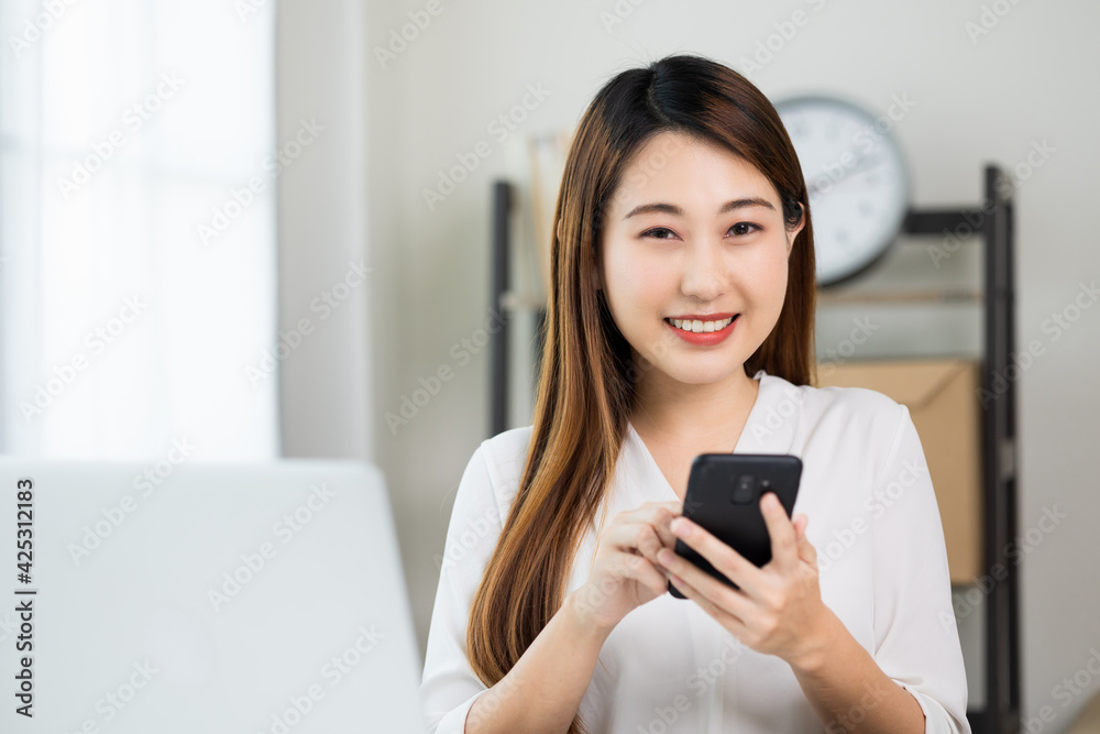 Young asian beautiful business woman using smartphone. Smiling charming happy young female texting touching on display of cell phone. Young asian beautiful business woman using smartphone. Smiling charming happy young female texting touching on display of cell phone.