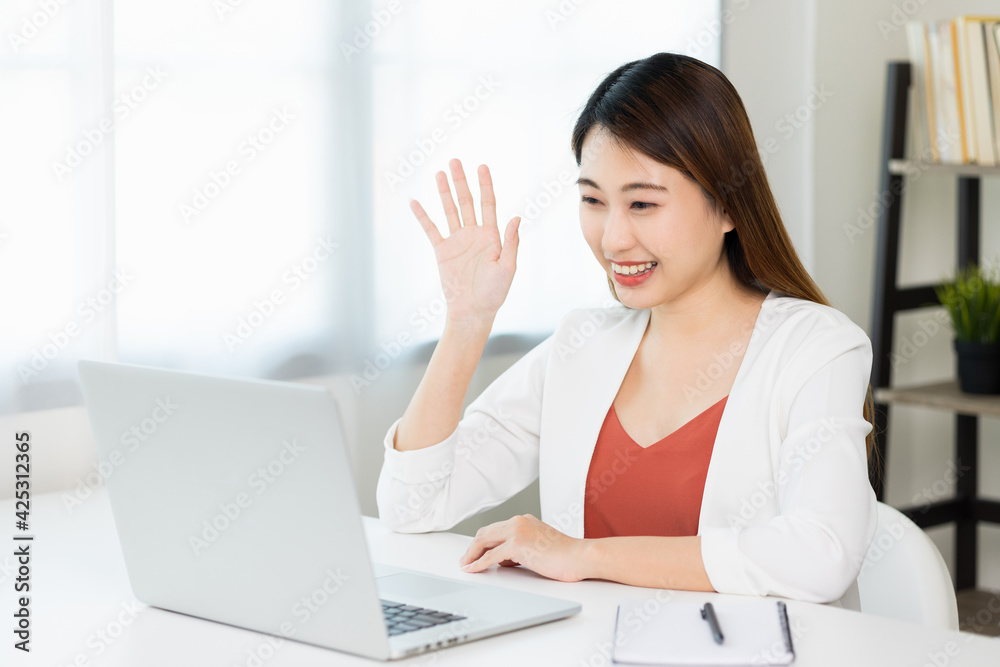 Young asian beautiful business woman working with laptop sitting at home. Smiling charming happy young female doing homework meeting conference with team at home. Young asian beautiful business woman working with laptop sitting at home. Smiling charming happy young female doing homework meeting conference with team at home.