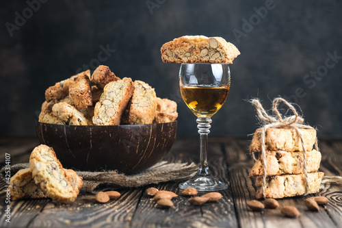 Biscotti cantuccini cookies, white dessert wine and almonds on a rustic background.