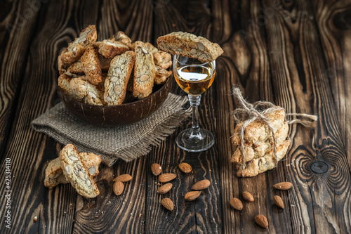 Biscotti cantuccini cookies, white dessert wine and almonds on a rustic background.
