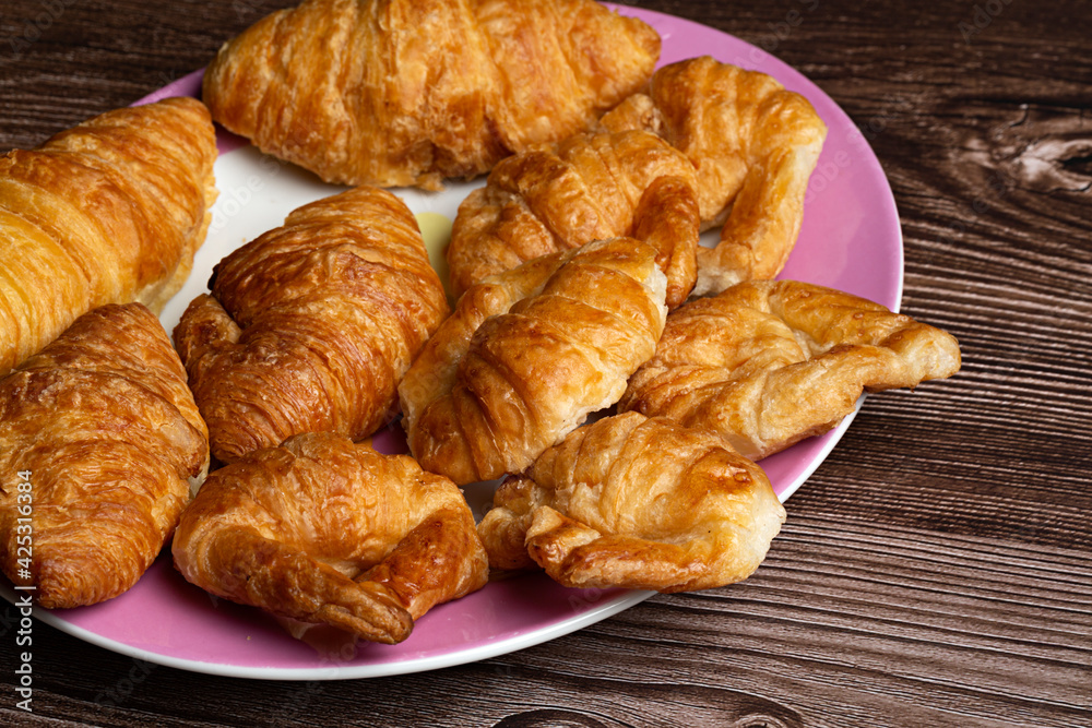 Croissants en plato sobre fondo de madera. Croissants en plato sobre fondo de madera.