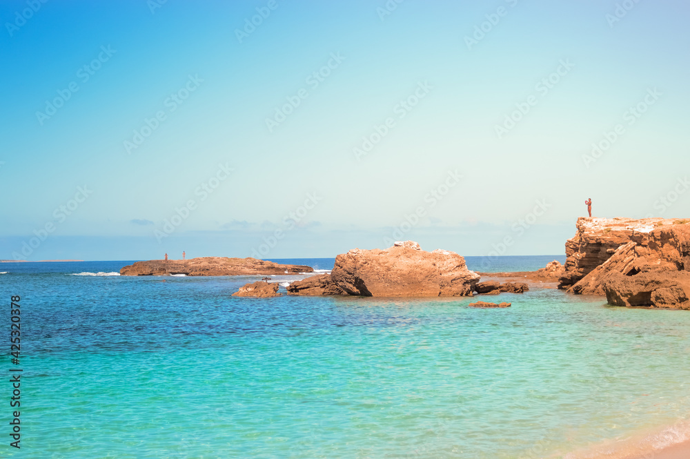 Beach view with orange rocks and turquoise water