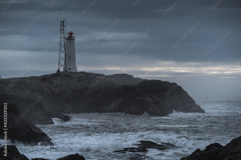 Lighthouse at Stokksnes coast in East Iceland ocean coastline. Dramatic moody landscape