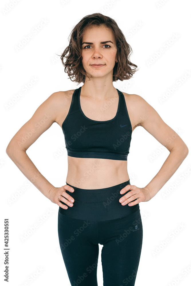 The girl in a black tracksuit on a white background. Sportswoman with a beautiful figure