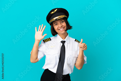 Photo Young airplane pilot over isolated blue background counting six with fingers