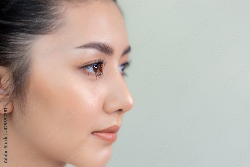 Naklejka premium Beautiful young asian woman with clean fresh skin look away Attractive girl beauty face care with beauty make up Facial treatment Cosmetology Beauty and Spa concept Close up beauty face copy space