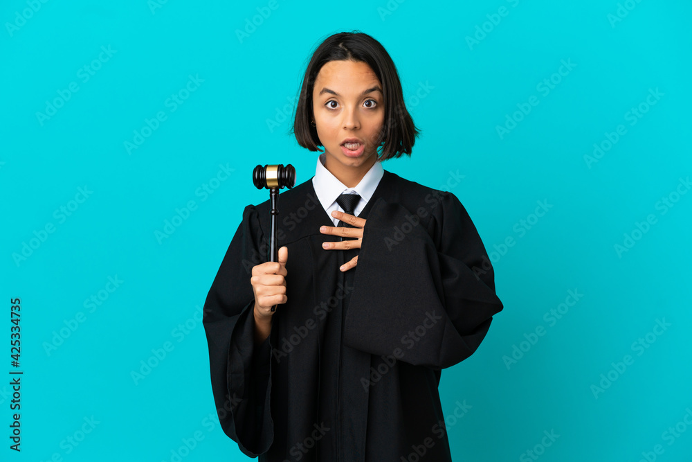 Judge over isolated blue background surprised and shocked while looking right