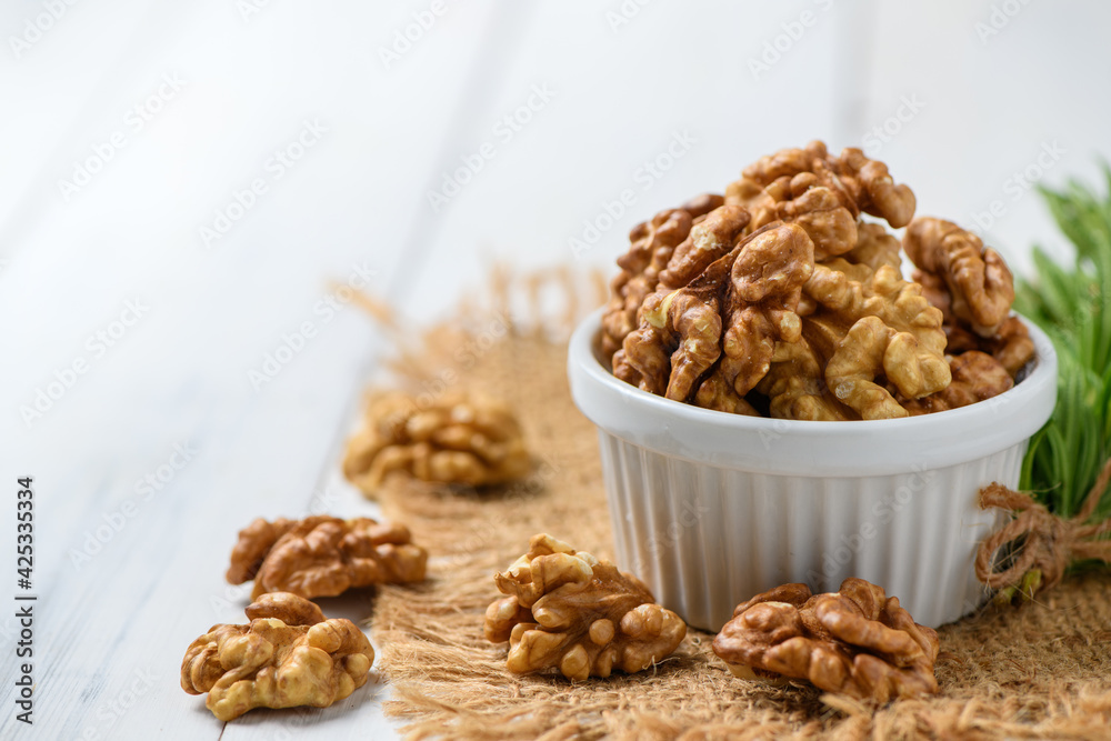 Walnut in white cup on wood background. healthy nuts concept. atherosclerosis. Walnut in white cup on wood background. healthy nuts concept. atherosclerosis.