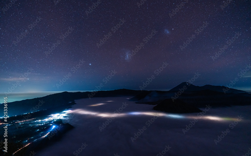 Mount Bromo volcano with million stars at night in East Java, Indonesia surround by morning fog.