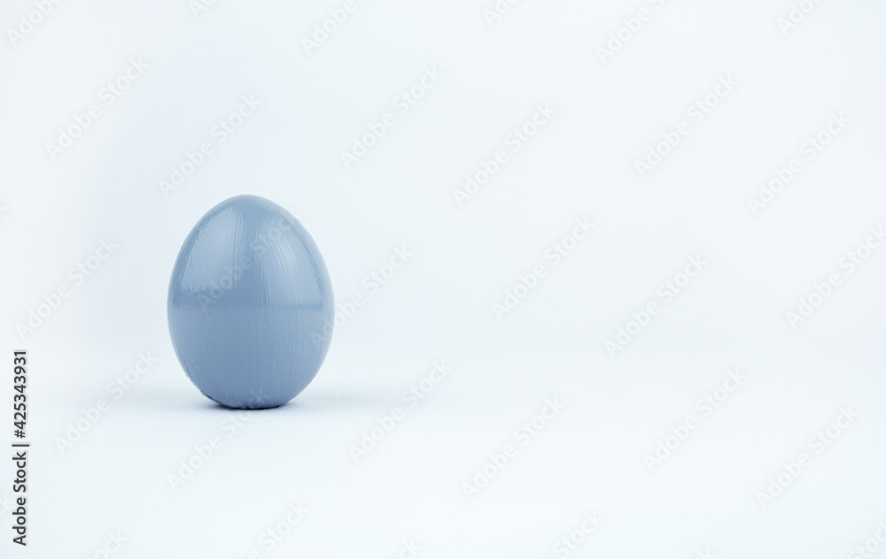 Gray easter egg isolated on white background. Chicken egg painted in gray color stands on surface, close up. Object for design to easter holiday