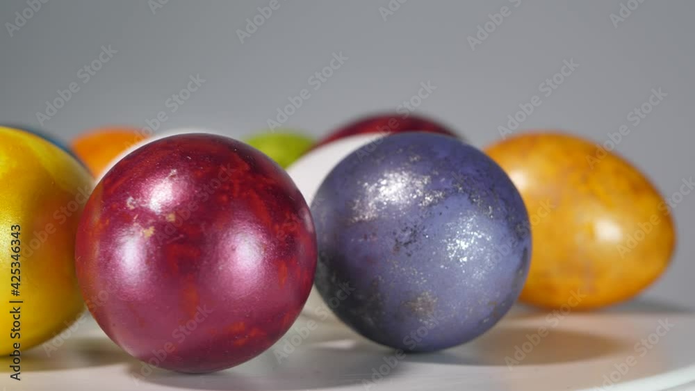 Colored eggs rotate in a basket. Easter eggs in all colors Colored eggs rotate in a basket. Easter eggs in all colors