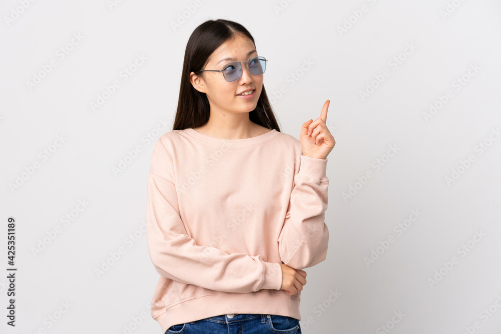 Young Chinese girl over isolated white background pointing up a great idea Young Chinese girl over isolated white background pointing up a great idea