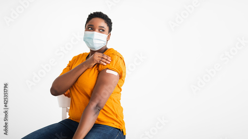 Vaccinated Black Woman Showing Arm With Adhesive Bandage, White Background