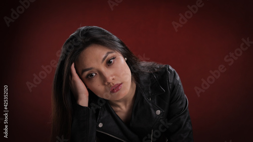 Young thoughtful woman in close-up - studio photography
