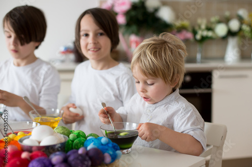 Children, boy siblings, coloring eggs for Easter