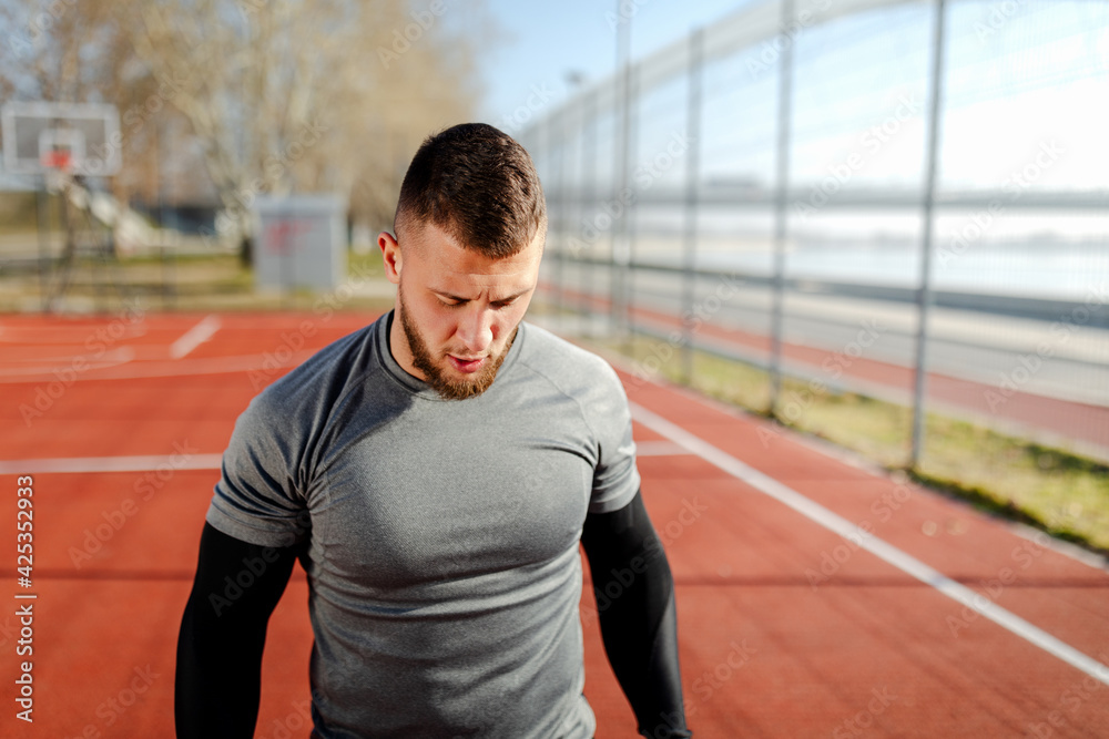 Young fit man is training and taking a break between sets.