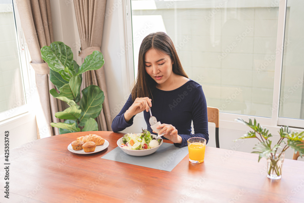 Portrait of happy playful asian girl eating fresh salad in diet concept