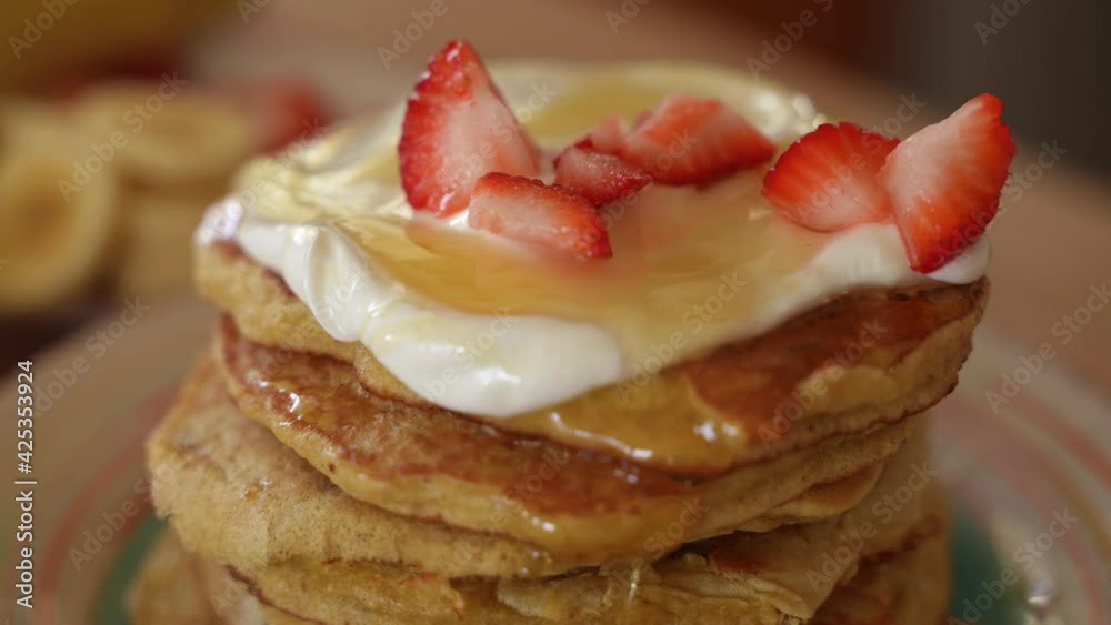 Fresh Strawberries Fall on Top of Stack of Homemade Pancakes, Slow Motion Close Up
