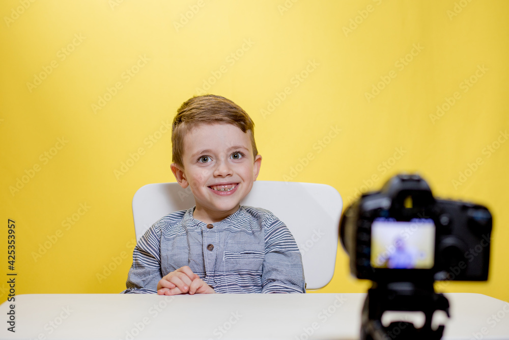 Child blogger videotapes his vlog at home. Boy recording his video blog. Little vlogger makes online streaming using camera Child blogger videotapes his vlog at home. Boy recording his video blog. Little vlogger makes online streaming using camera