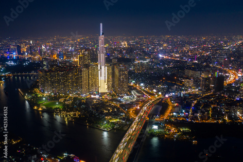 pic evening aerial panorama of Saigon, Ho Chi Minh City, Vietnam featuring all key buildings of the city skyline and the Saigon riverfront with beautiful light reflections on the calm water
