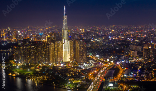 Wallpaper Mural pic evening aerial panorama of Saigon, Ho Chi Minh City, Vietnam featuring all key buildings of the city skyline and the Saigon riverfront with beautiful light reflections on the calm water Torontodigital.ca