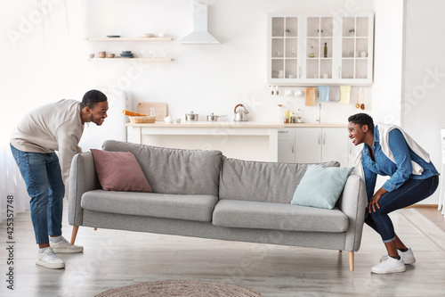 Happy black couplereplacing furniture in their new apartment photo