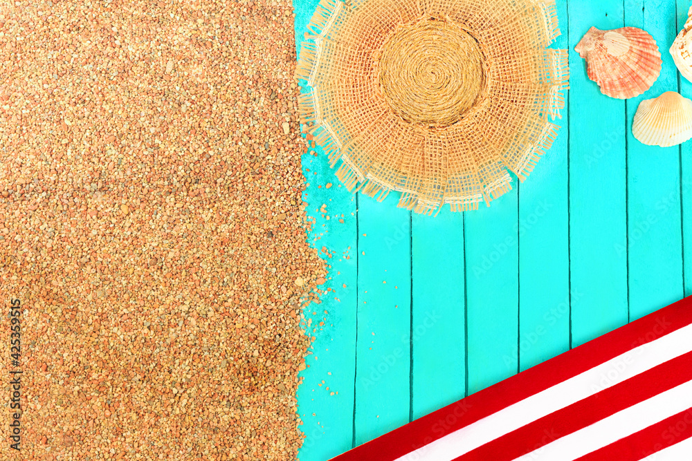 Beach layout. Pebbled sand with azure wooden pier or sun lounger or towel. Red-white sunbed, straw hat, seashells. Travel and tourism. Copy space
