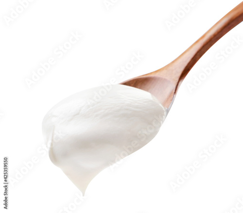 Quadro em tela Sour cream in a wooden spoon on a white background. Isolated