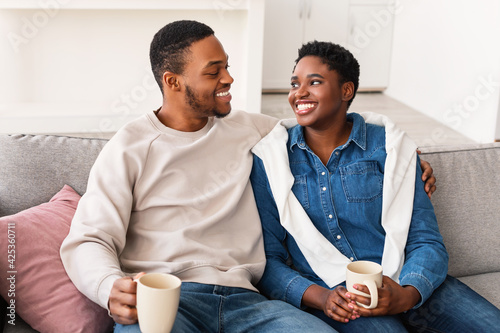 Black couple talking and spending time together sitting on couch